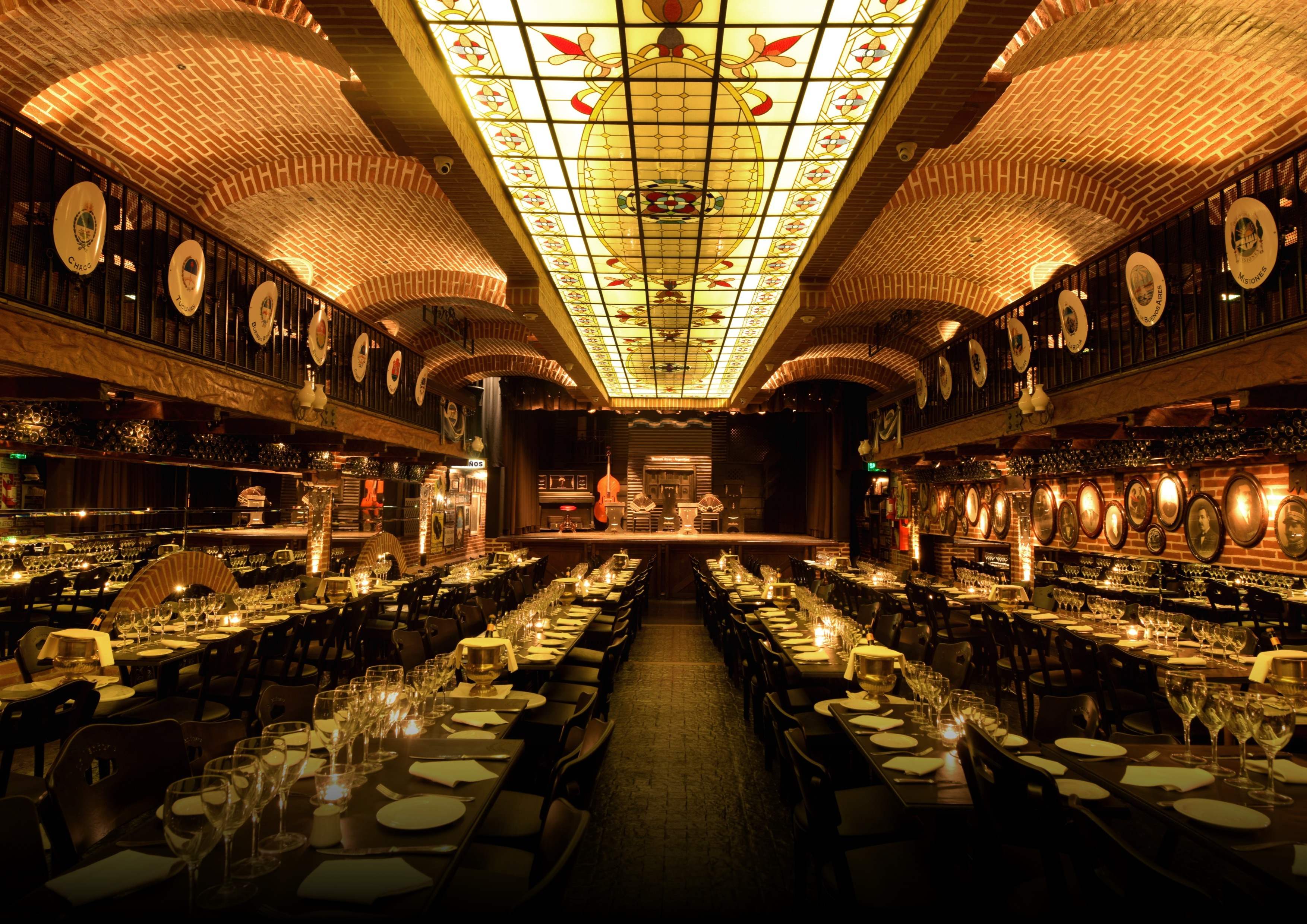 La Ventana dining room in Buenos Aires, with a stained-glass ceiling, brick arches and tables set for dinner.