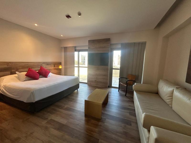 Room at Mod Hotel Mendoza with a double bed, a sofa and circulation space around the bed.
